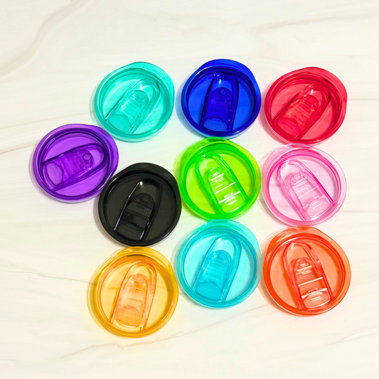 An array of colored acrylic lids for 20oz tumblers, displayed on a marble surface. The colors are : purple, turquoise, blue, red, pink, lime green, black, yellow, light blue and orange
